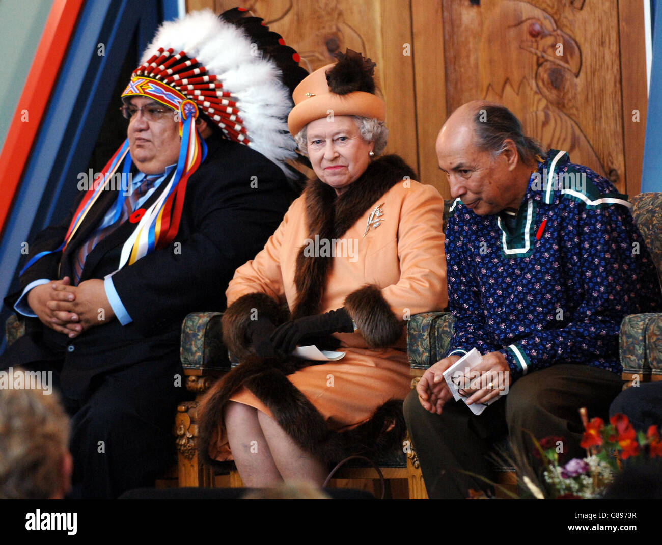 Queen Elizabeth II sits between First Nation Indians, Cree Chief, Alphonse Bird (left) of the Federation of Indian Nations and Doctor Eber Hampton during her visit, to the First Nations University in Regina. Stock Photo