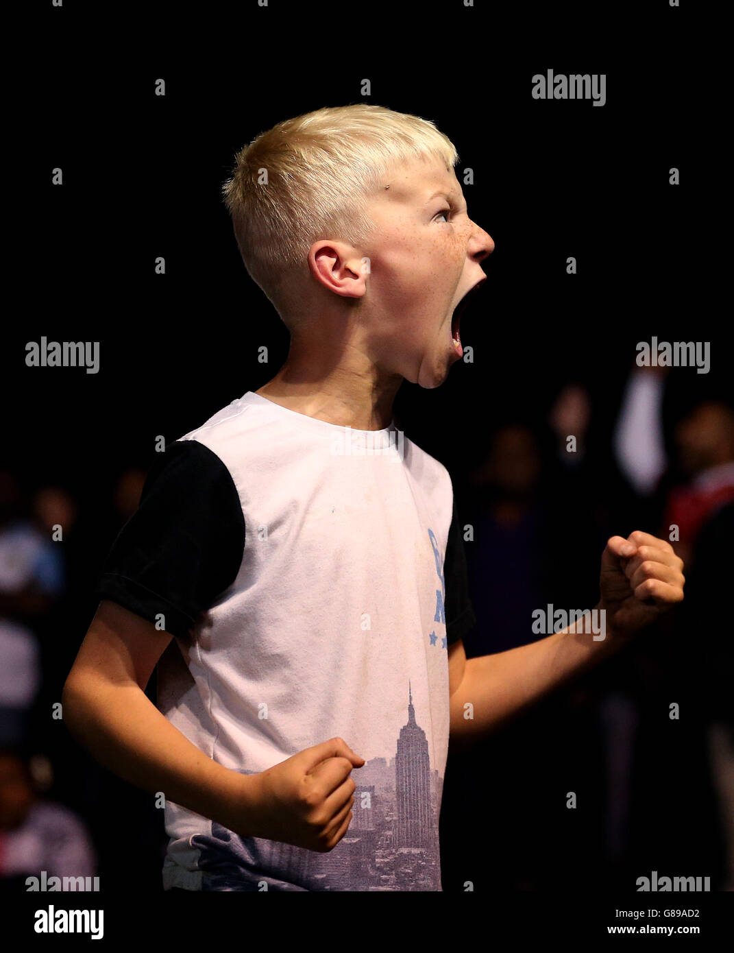 A young England fans celebrates while watching the game at the Fan zone