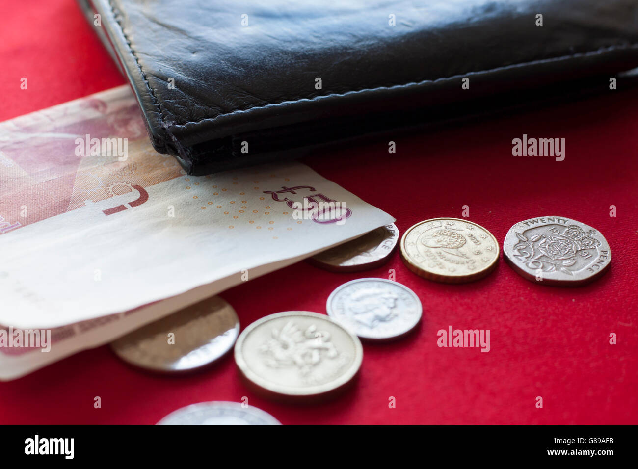 British pound in banknote and coins with black wallet Stock Photo Alamy