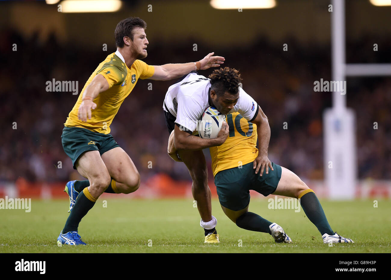 Fiji's Metuisela Talebula is tackled by Australia's Bernard Foley and Rob Horne (left) during the Rugby World Cup match at the Millennium Stadium, Cardiff. Stock Photo