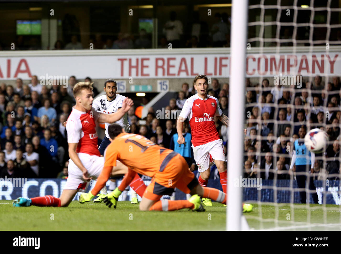 Tottenham Hotspur's Nacer Chadli (second left) sees his cross turned in for an own goal by Arsenal's Calum Chambers (left) Stock Photo