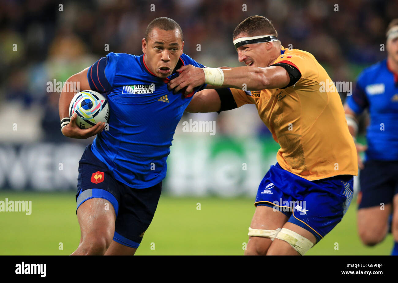 France's Gael Fickou attempts to hand off Romania's Mihai Macovei (right) during the Rugby World Cup match at The Olympic Stadium, London. PRESS ASSOCIATION Photo. Picture date: Wednesday September 23, 2015. See PA story RUGBYU France. Photo credit should read: Mike Egerton/PA Wire. Still image use only. Use implies acceptance of Section 6 of RWC 2015 T&Cs at:http://bit.ly/1MPElTL Call +44 (0)1158 447447 for further info. Stock Photo