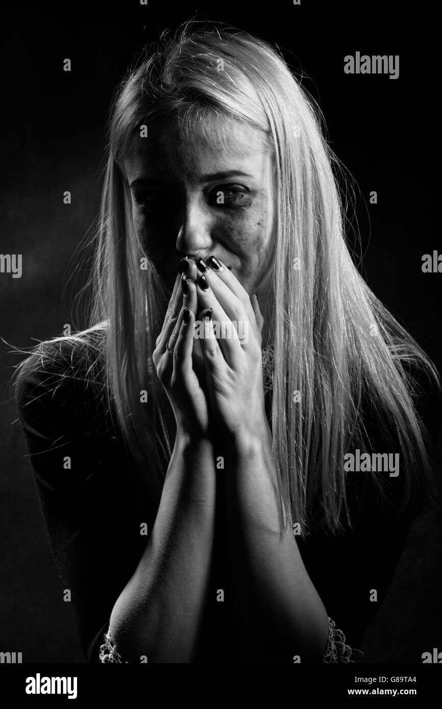 woman with smeared cosmetics crying on black background, monochrome Stock Photo