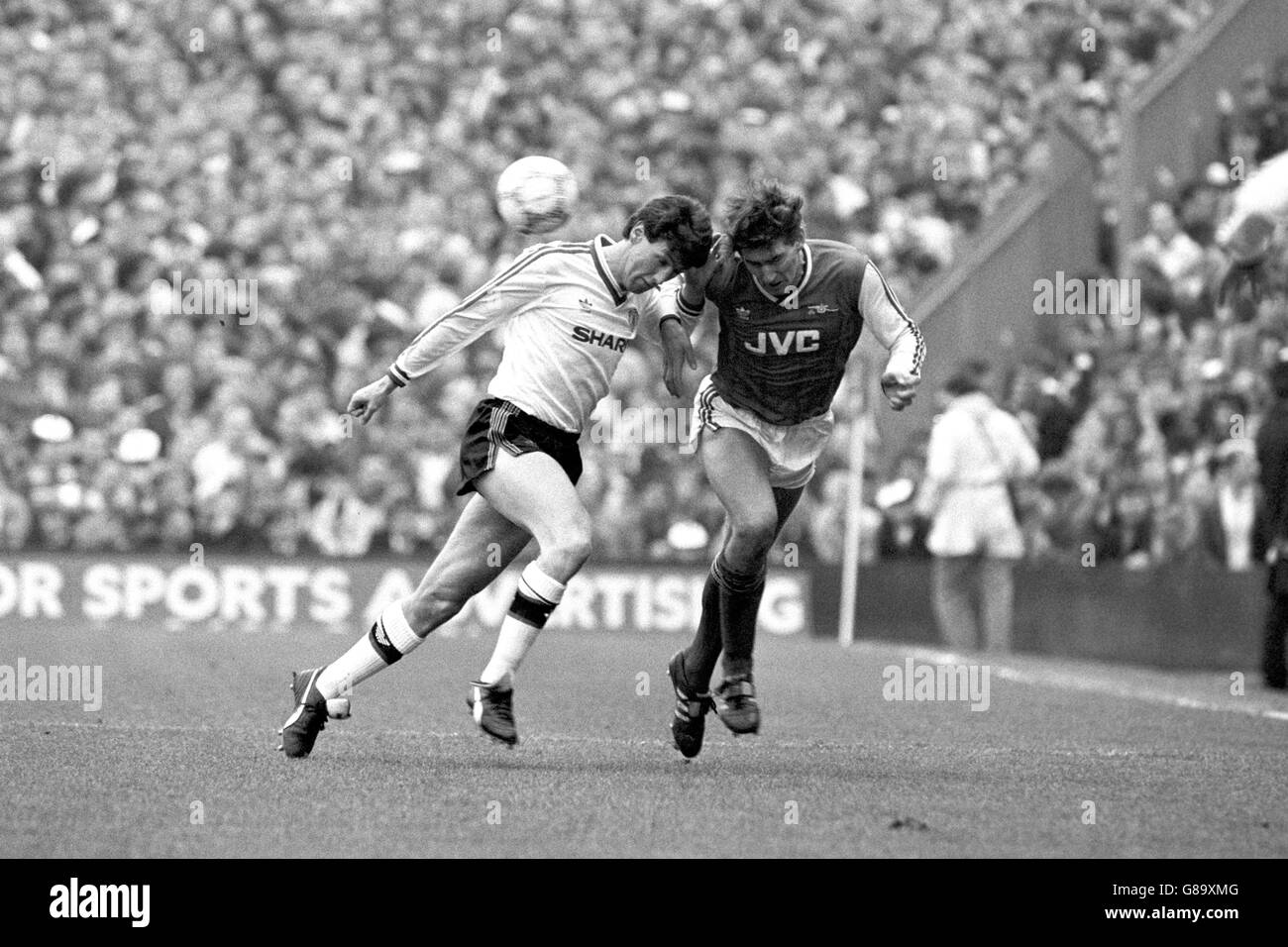 Soccer - FA Cup - Fifth Round - Arsenal v Manchester United - Highbury. Arsenal's Tony Adams (r) heads the ball away from Manchester United's Peter Davenport (l) Stock Photo