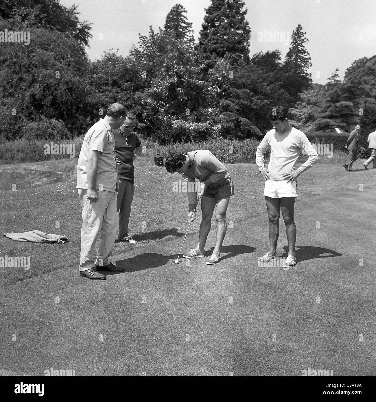 Chile's Leonel Sanchez (c) practises his putting as teammate Roberto ...