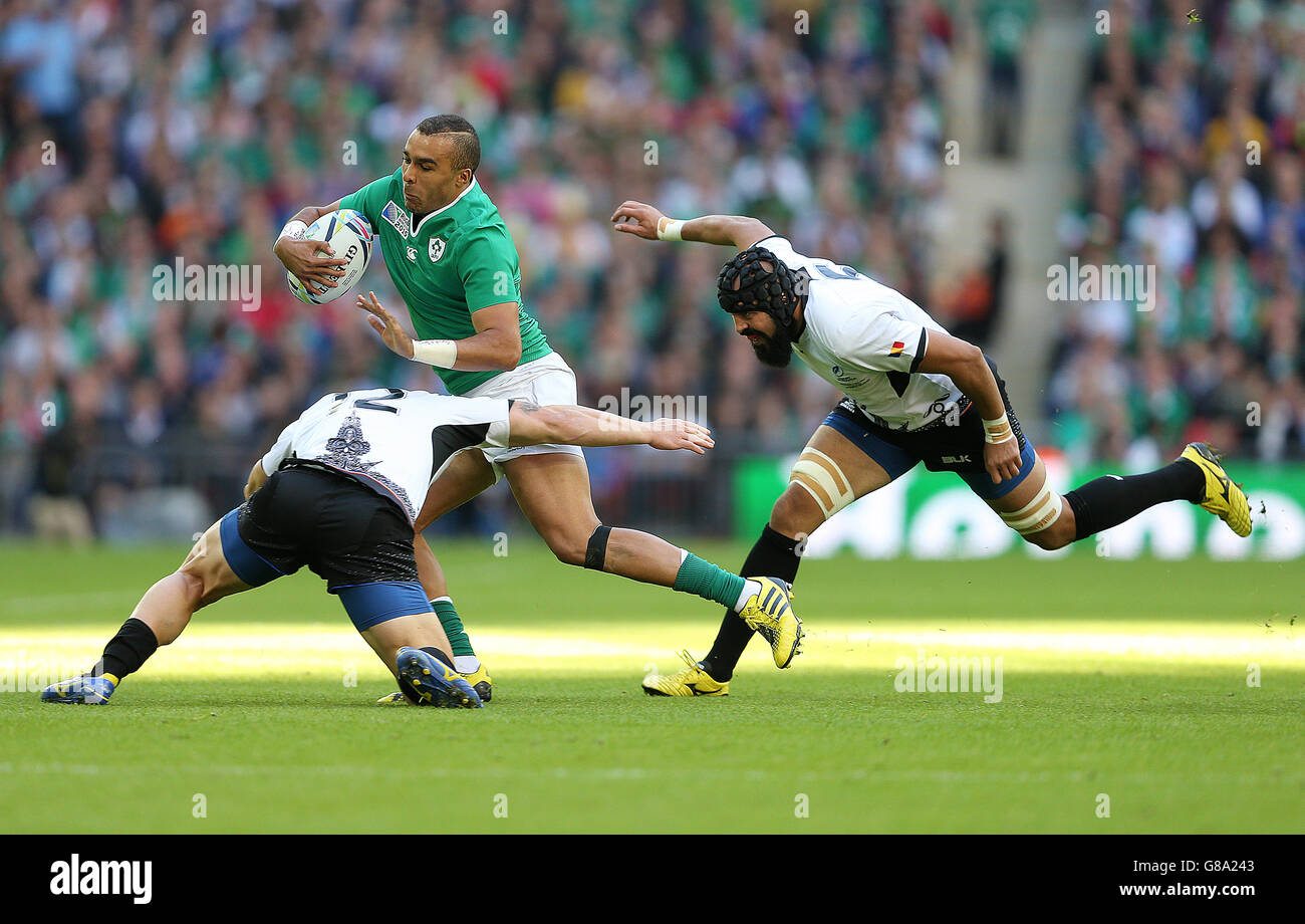 Ireland's Simon Zebo (centre) is tackled by Romania's Csaba Gal (left) and Viorel Lucaci (right) during the Rugby World Cup match at Wembley Stadium, London. Stock Photo