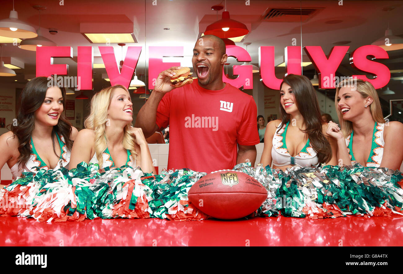 The Miami Dolphin Cheerleaders Etta, Dancia, Britt and Paige and UK NFL Ambassador Osi Umenyiora, dual Super Bowl winner who recently retired from the game, celebrate the launch of the NFL and Five Guys partnership at the burger restaurant in Covent Garden, London. Stock Photo