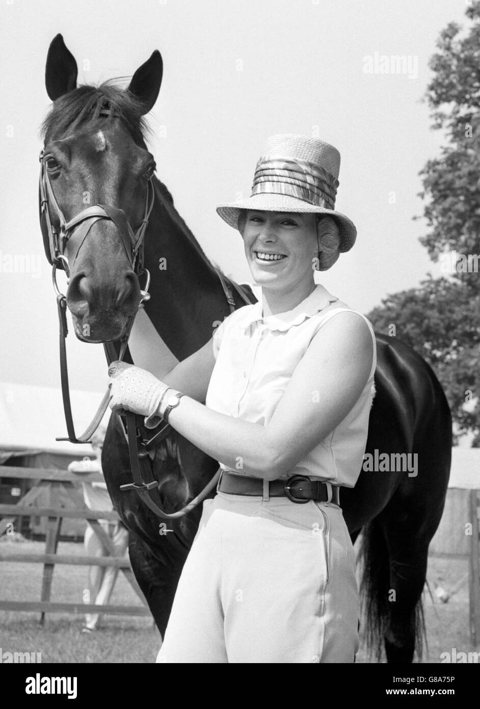 Gail Ross, of Alberta, Canada, finds summer comfort in a straw topper at Richmond Royal Horse Show, Surrey. She is pictured with her black gelding The Hood, whom she is competing in Class 7, the Ladies' Jumping Competition. Stock Photo
