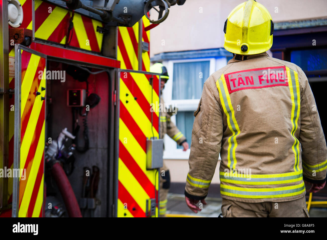 Emergency services: Firemen attending to a small kitchen fire in a house in Aberystwyth Wales UK Stock Photo