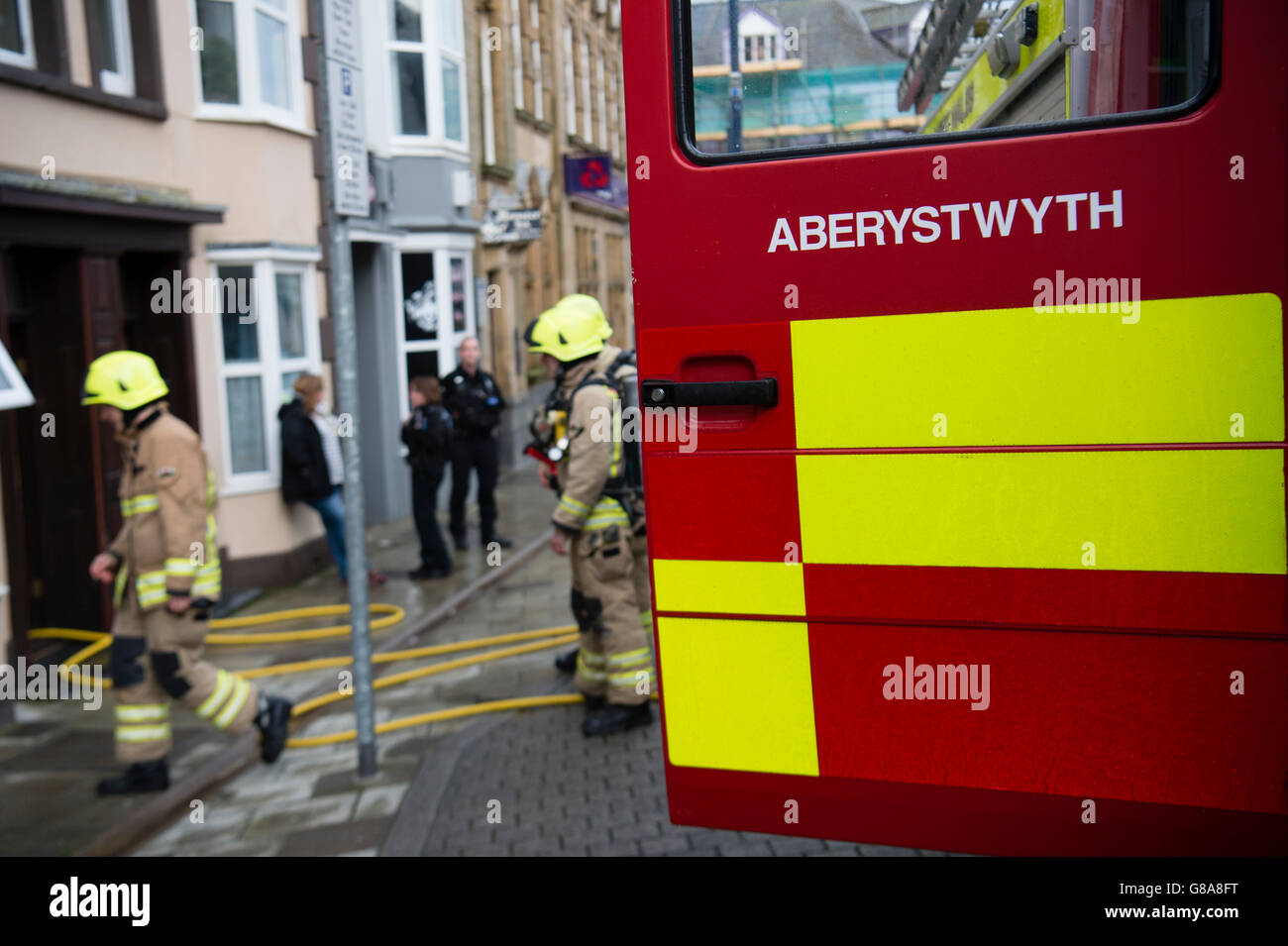 Emergency services: Firemen attending to a small kitchen fire in a house in Aberystwyth Wales UK Stock Photo