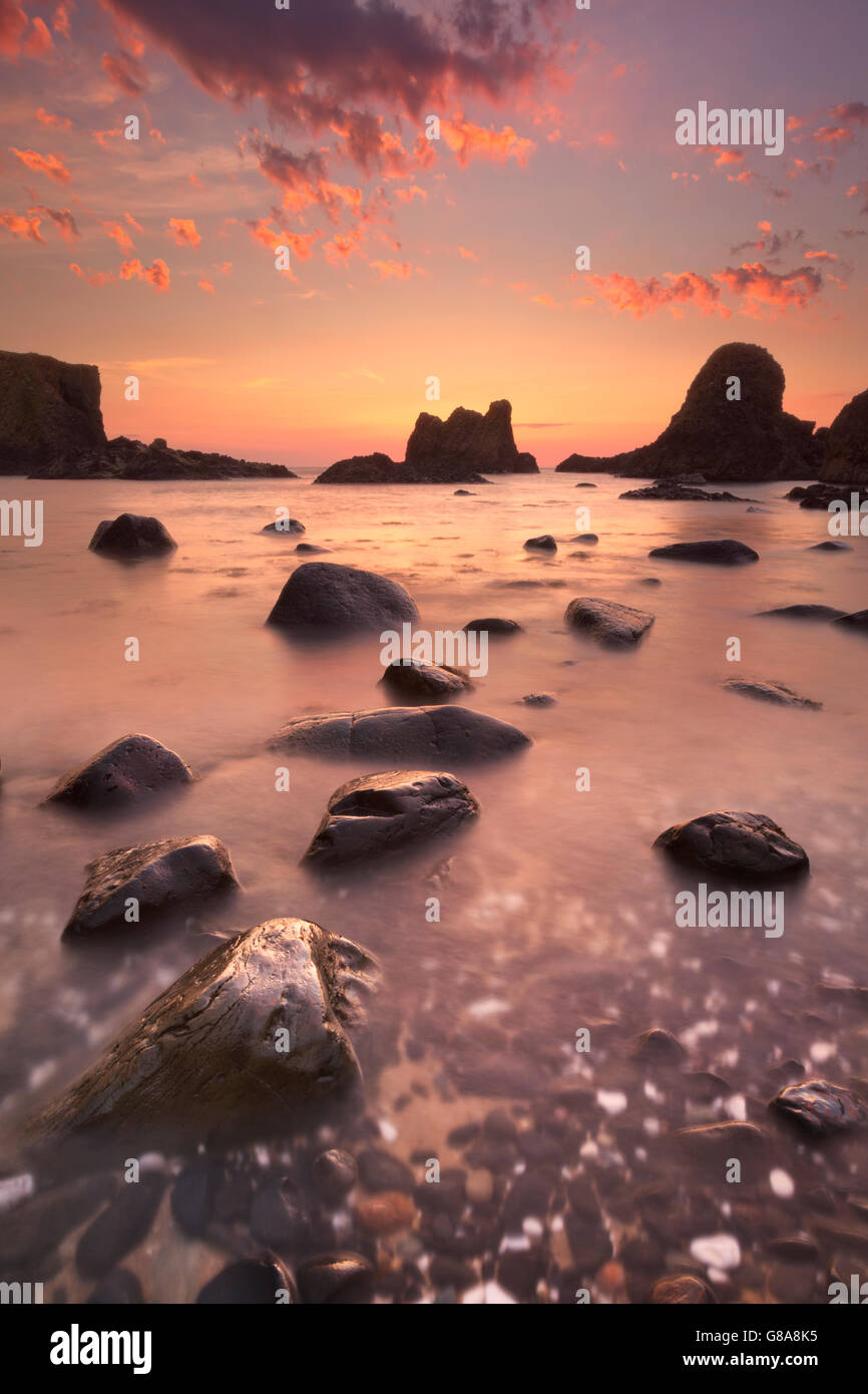 Sea stacks along the coast near Ballintoy Harbour on the Causeway Coast of Northern Ireland at sunset. Stock Photo