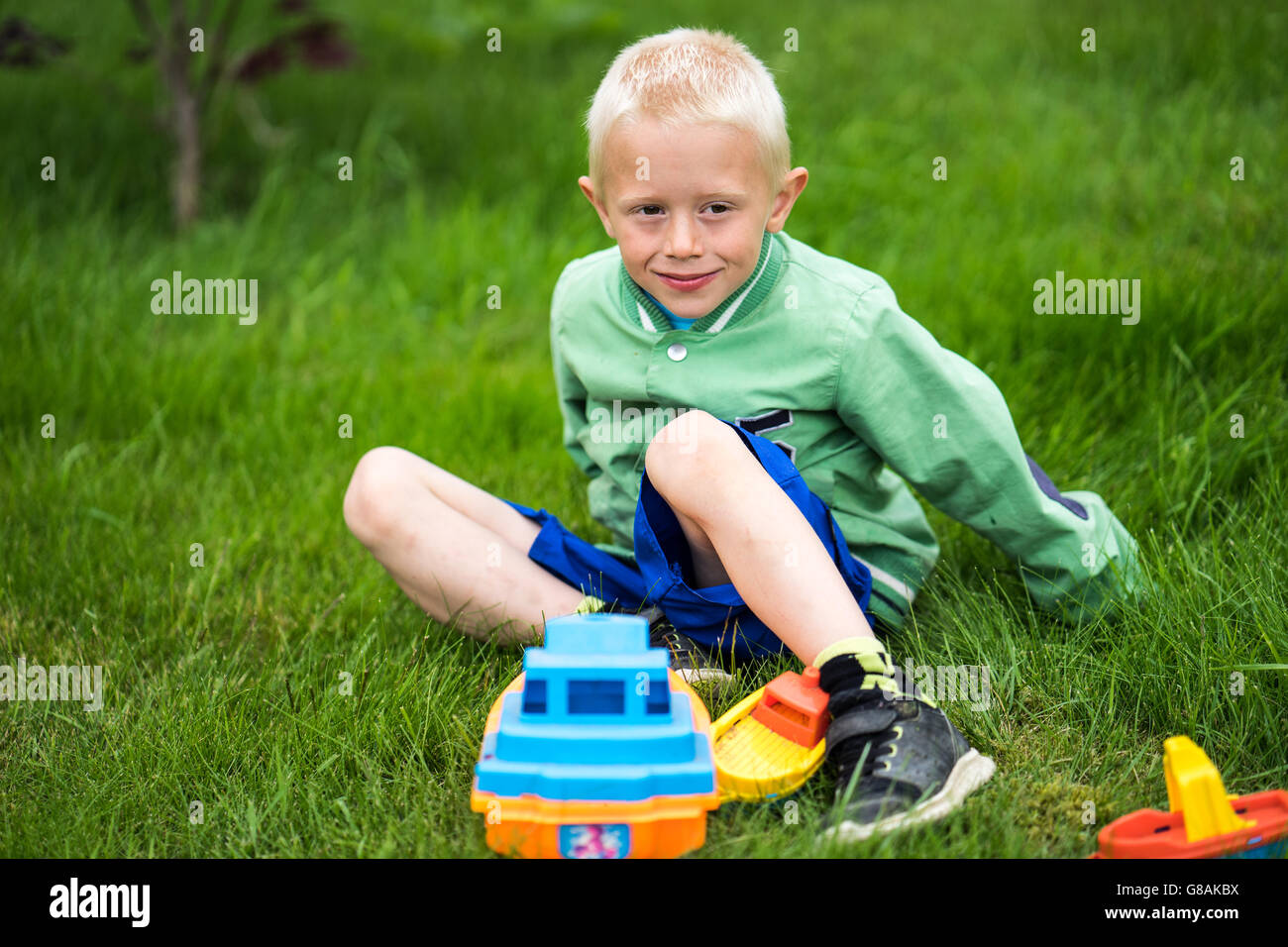Little boy playing with his toys in the garden Stock Photo - Alamy
