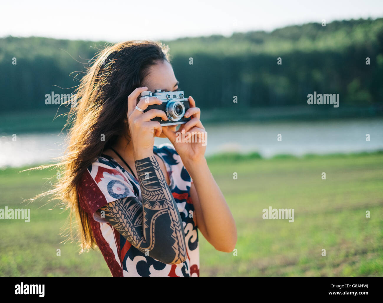 Woman with tattoo taking a photo Stock Photo