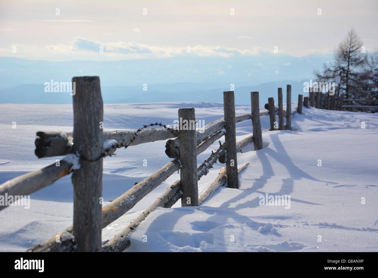 Old wooden fence on a mountain after heavy snowfall Stock Photo
