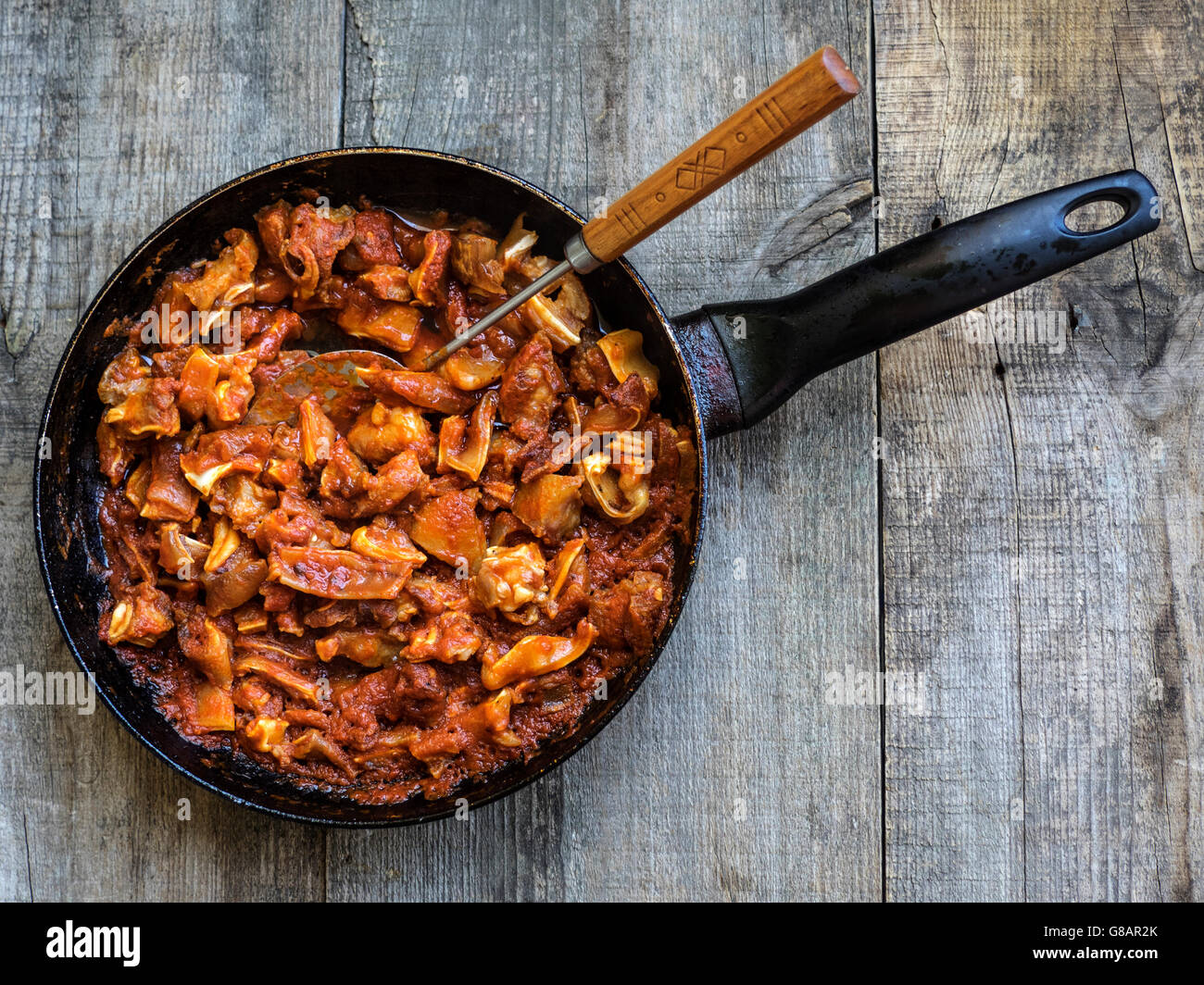 Pork ears and tomato sauce in frying pan Stock Photo