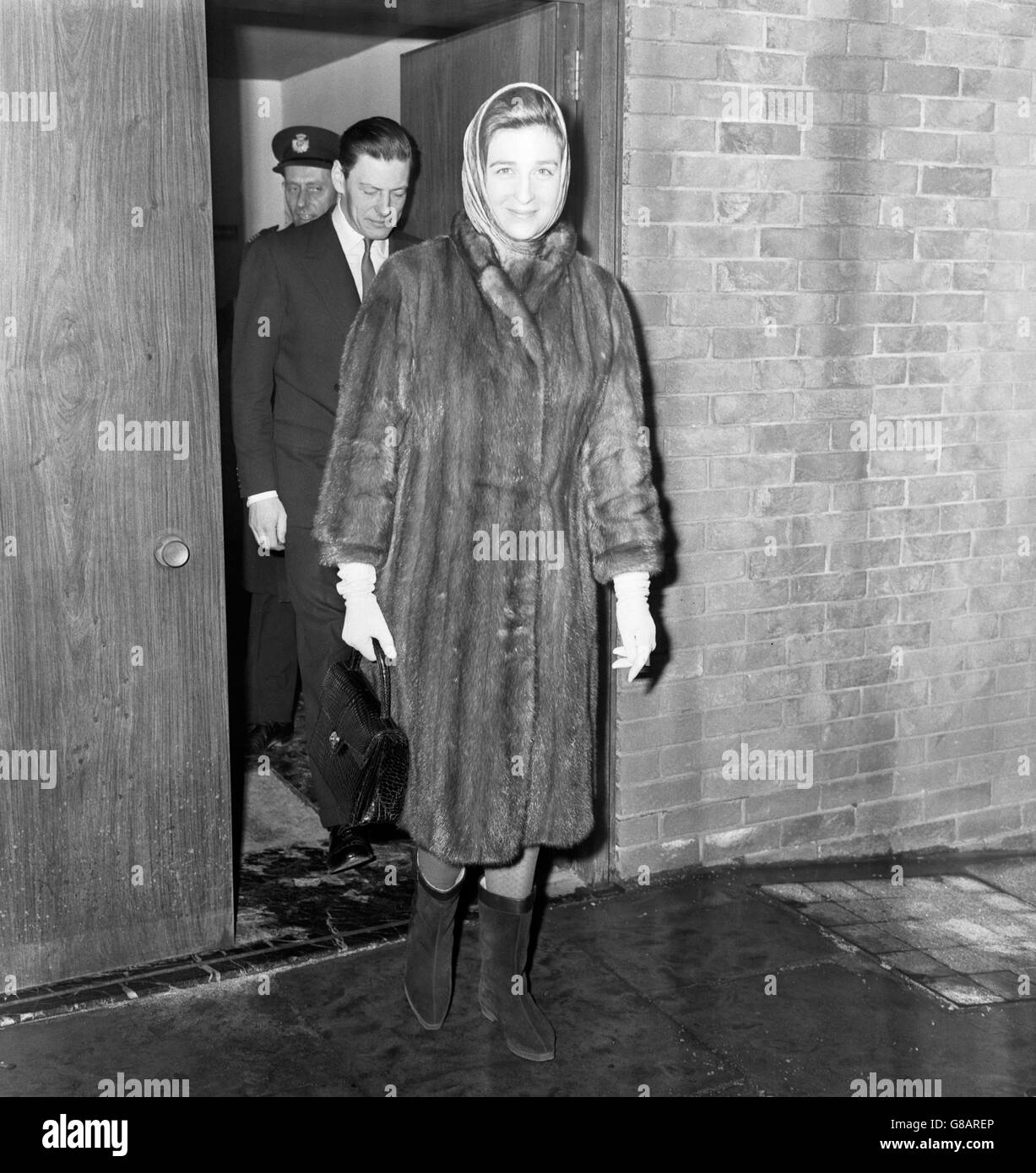 Princess Alexandra is dressed for the snow in a headscarf, fur coat and calf-length boots at London Airport. She was leaving for Athens with her husband Angus Ogilvy. Stock Photo