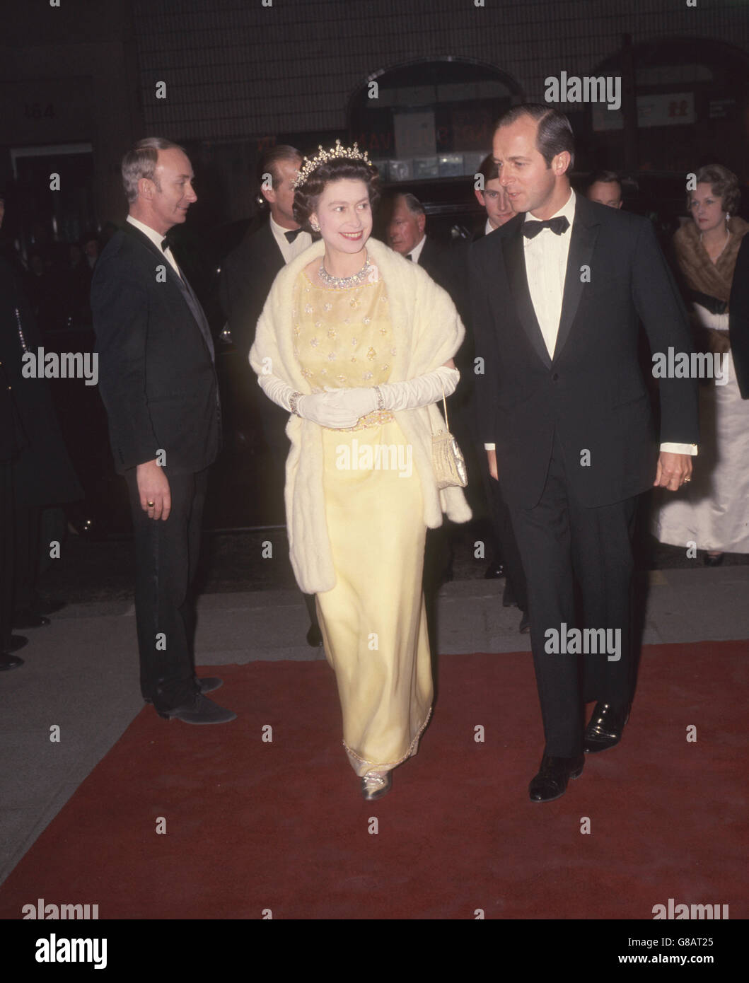 The Queen arriving at the Saville Theatre, London, to attend a performance of 'The Mikado' by the D'Oyly Carte Company in aid of the Royal General Theatrical Fund Association. She was accompanied by the Duke of Edinburgh and the Prince of Wales (not pictured). Stock Photo