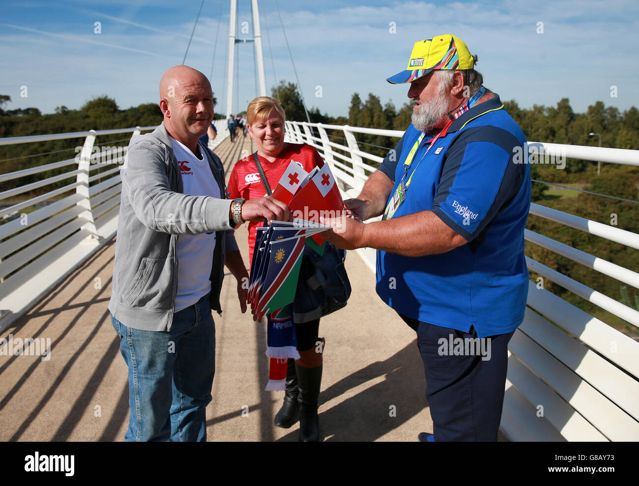 Fans pick up miniature flags for either Tonga or Namibia on the Sandy Park Pesestrian Bridge before the Rugby World Cup match at Sandy Park, Exeter. Stock Photo