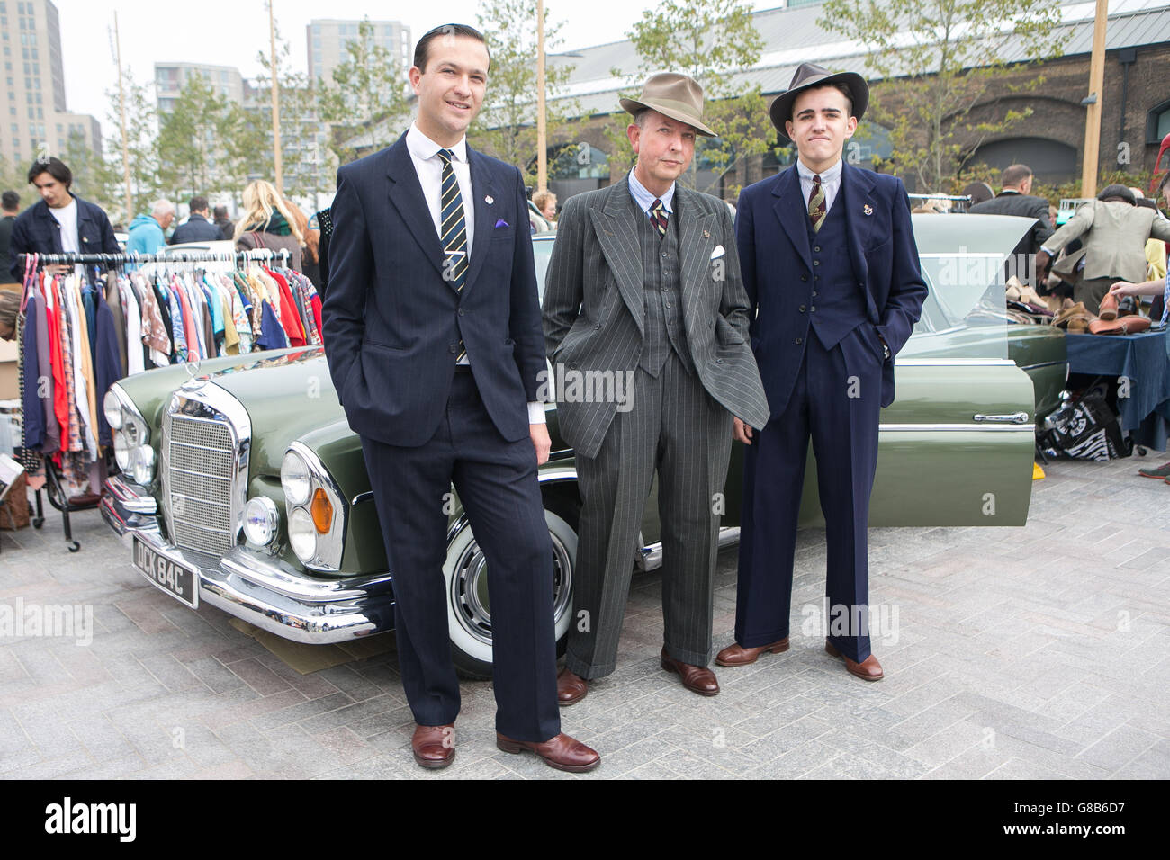 (Left to right) Bradley Cooper, Alan Morris and Jake Drudge pose in front of a vintage Mercedes-Benz 220 SE from 1965 at The Classic Car Boot Sale in Lewis Cubitt Square, London. Stock Photo