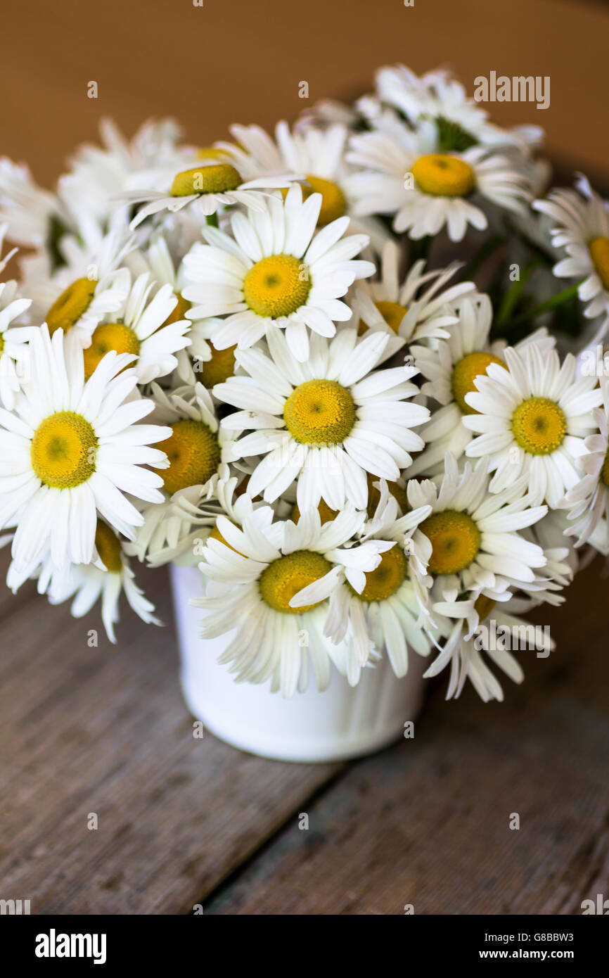 Bouquet of chamomile in a vase on the wooden table background Stock ...