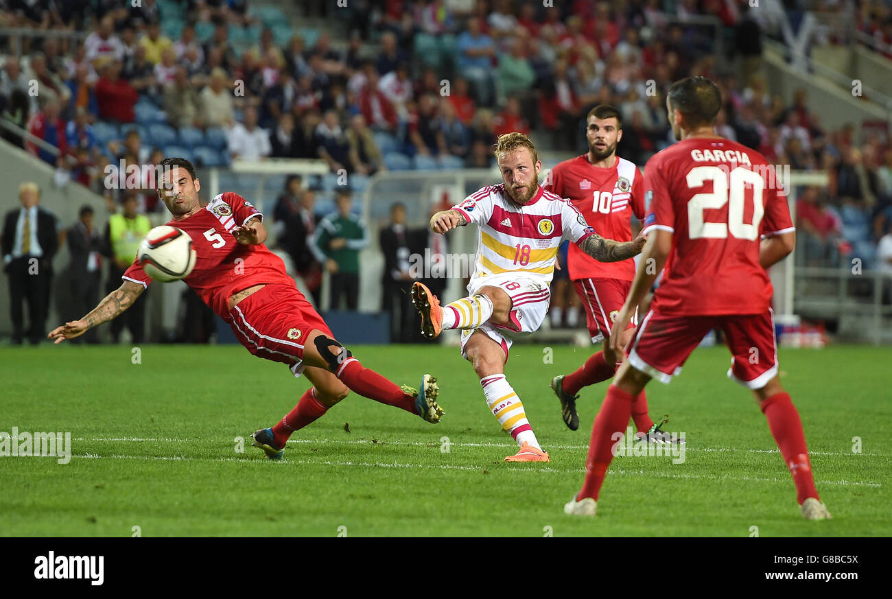 Scotland's Johnny Russell shoots past Gibraltar's Ryan Casciaro (left), during the European Championship Qualifying match at the Estadio Algarve, Faro, Portugal. Stock Photo