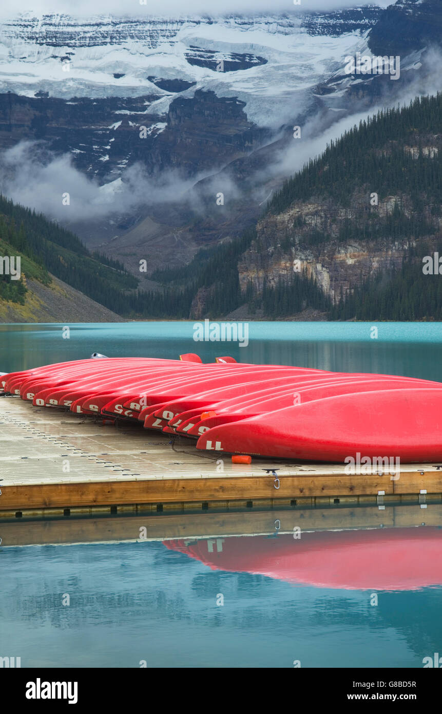 Red canoes on dock, Lake Louise, Banff National Park Stock Photo