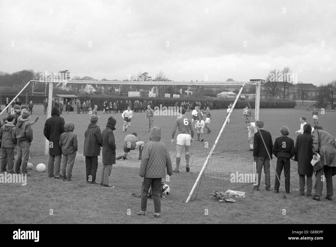 Schoolboys look on as members of the England football team train at the Bank of England Sports Ground in Roehampton. They are preparing for the international match against West Germany at Wembley. Stock Photo