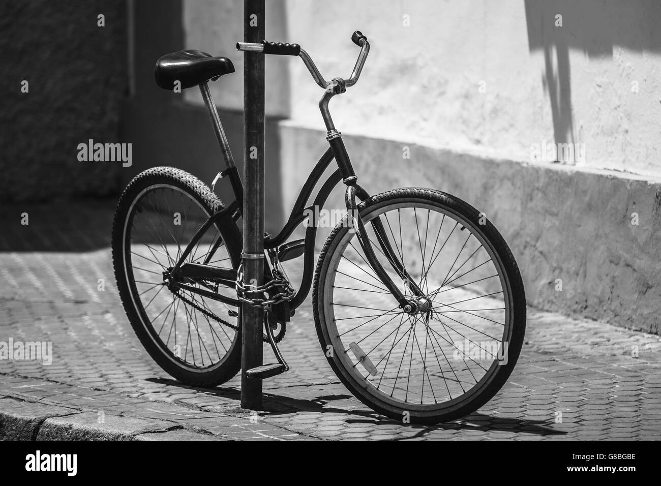 Old Black Bicycle Parking On Street In European City. Photo In Black And White Colors Stock Photo