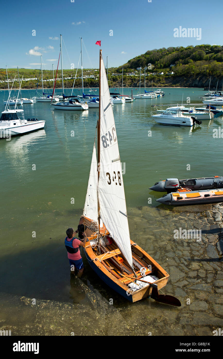 UK, Wales, Ceredigion, New Quay, Harbour, woman preparing small sailing dinghy at slipway Stock Photo
