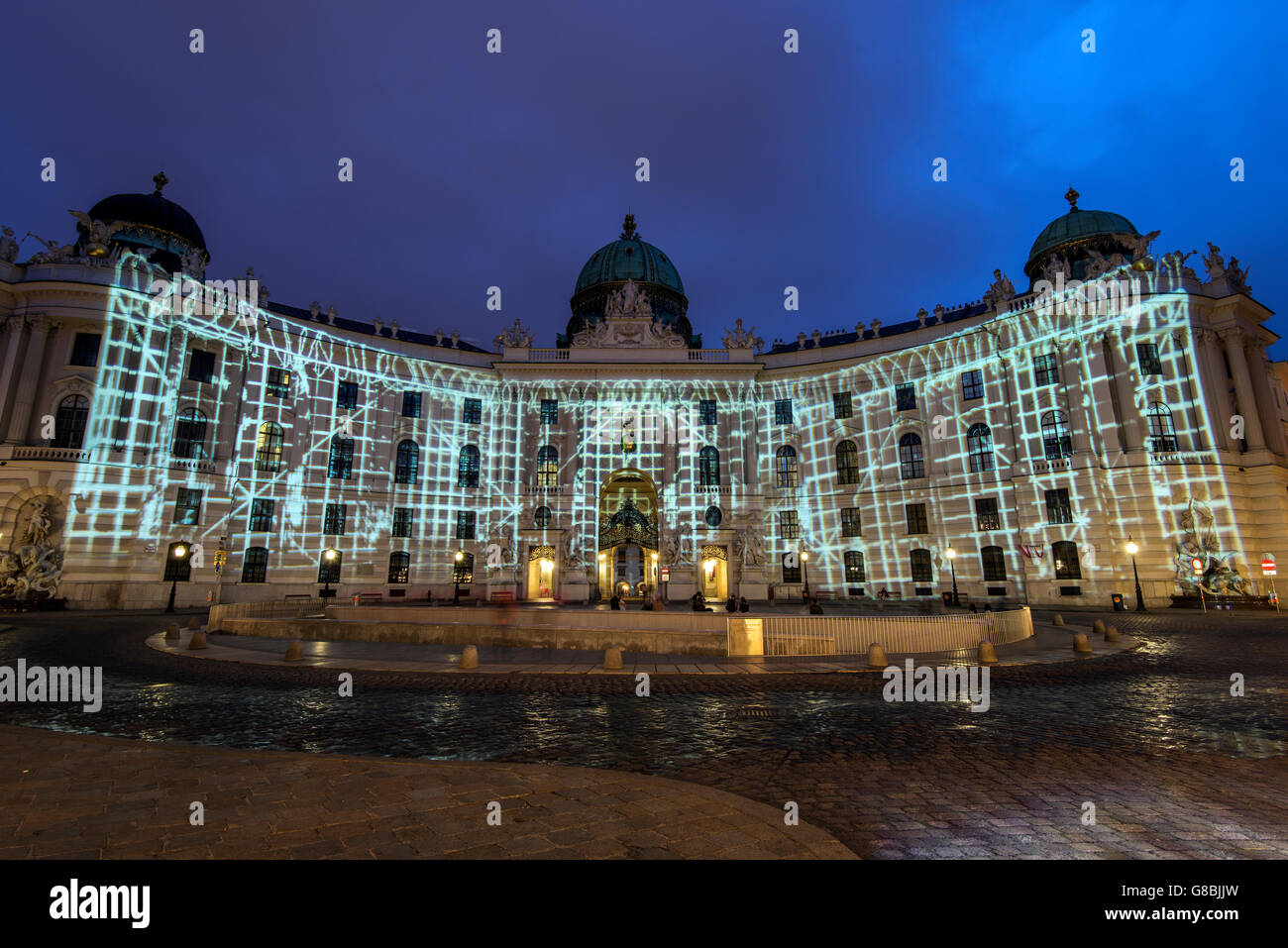 Night view of Michaelerplatz with lights show on the facade of Hofburg Palace, Vienna, Austria Stock Photo