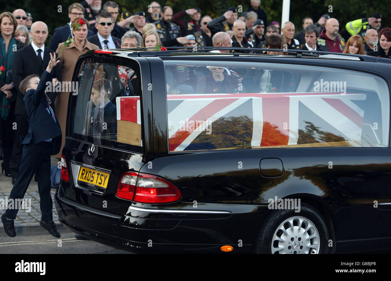 Flight Lieutenant Geraint 'Roly' Roberts son Samuel, 10, throws a rose onto the hearse at RAF Brize Norton in Oxfordshire following the repatriation of Flight Lieutenant Alan Scott and Roberts, who died after their Puma Mk 2 helicopter crashed while landing at Nato's Resolute Support mission headquarters in Kabul, Afghanistan. Stock Photo