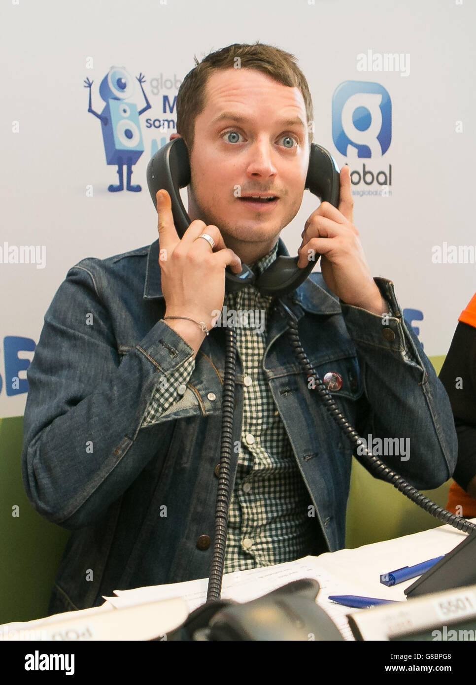 Elijah Wood, actor, posesfor a picture in the phone room to support
