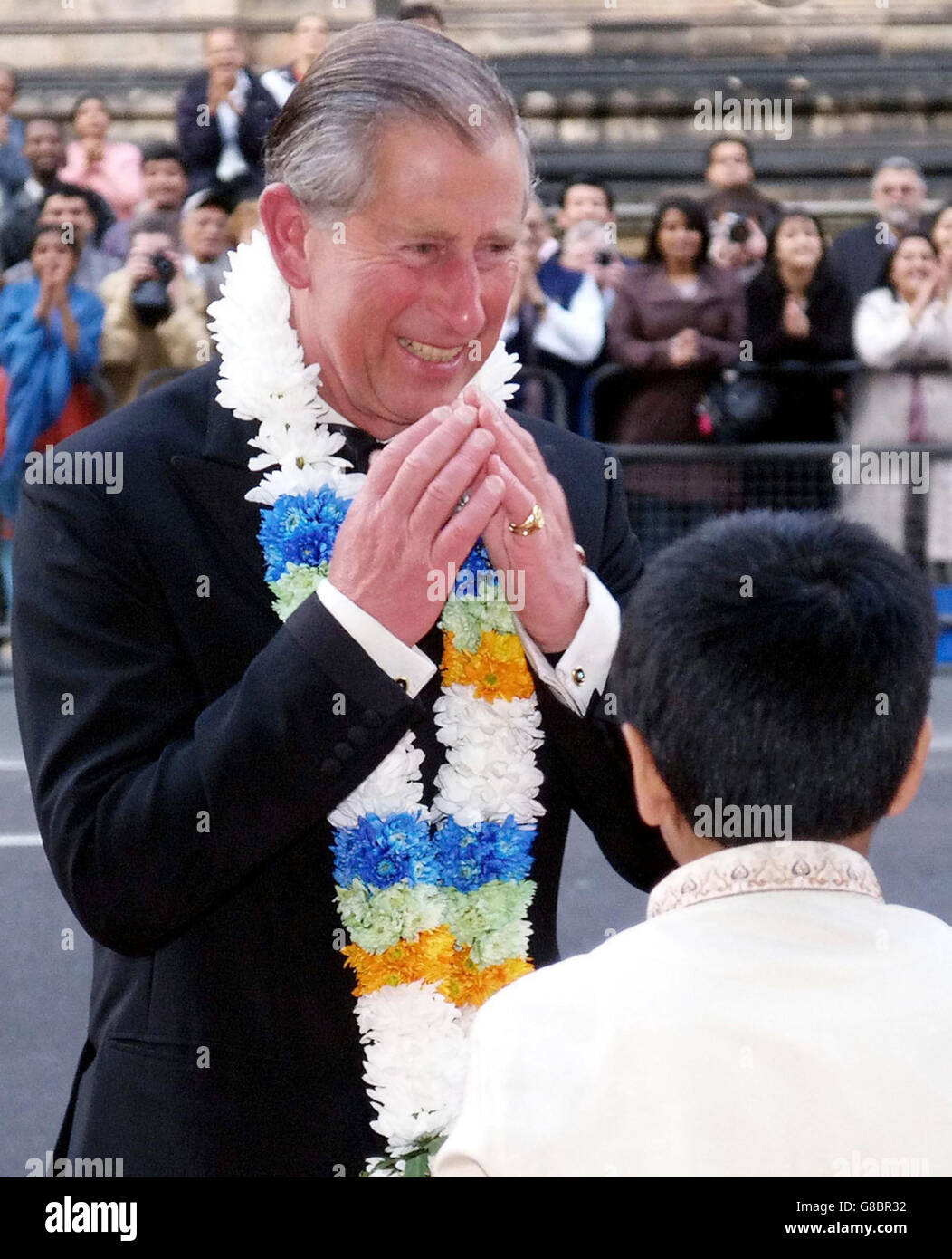 The Prince of Wales thanks a young boy for the garlands he placed round his neck on her arrival. The Prince and the Duchess of Cornwall were adorned with the garlands as they embraced the customs of a traditional Indian welcome when they arrived to see the IMAX film Mystic India. Stock Photo