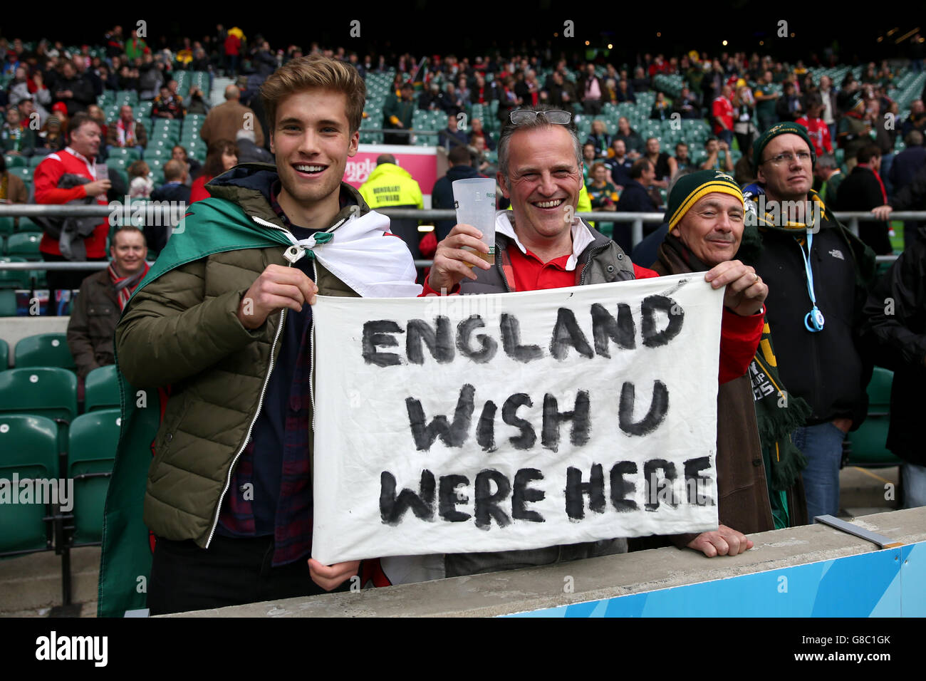 Wales fans in the stands with a sign reading 'England Wish U Were Here' during the Rugby World Cup game at Twickenham Stadium, London. Stock Photo