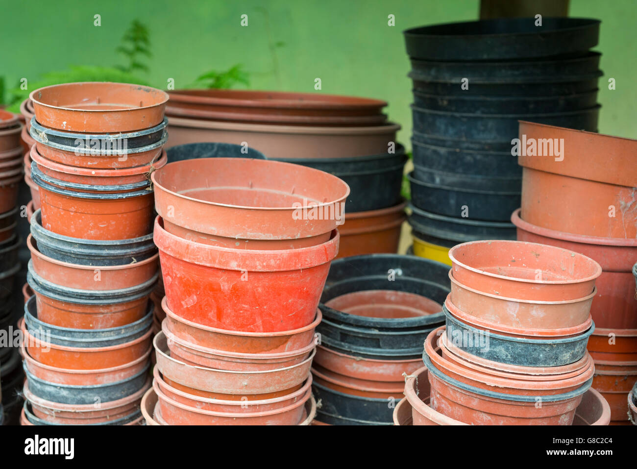 Empty plastic plant pots stacked on a shelf in a polytunnel Stock Photo
