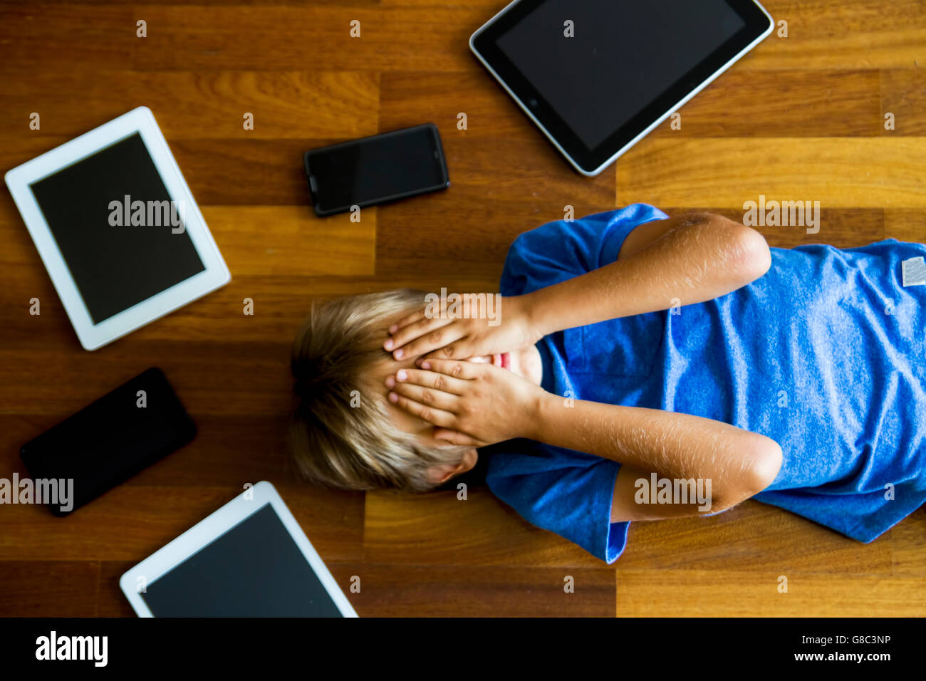 Little boy sad, tired and stressed with tablet computer PC. Kid holding