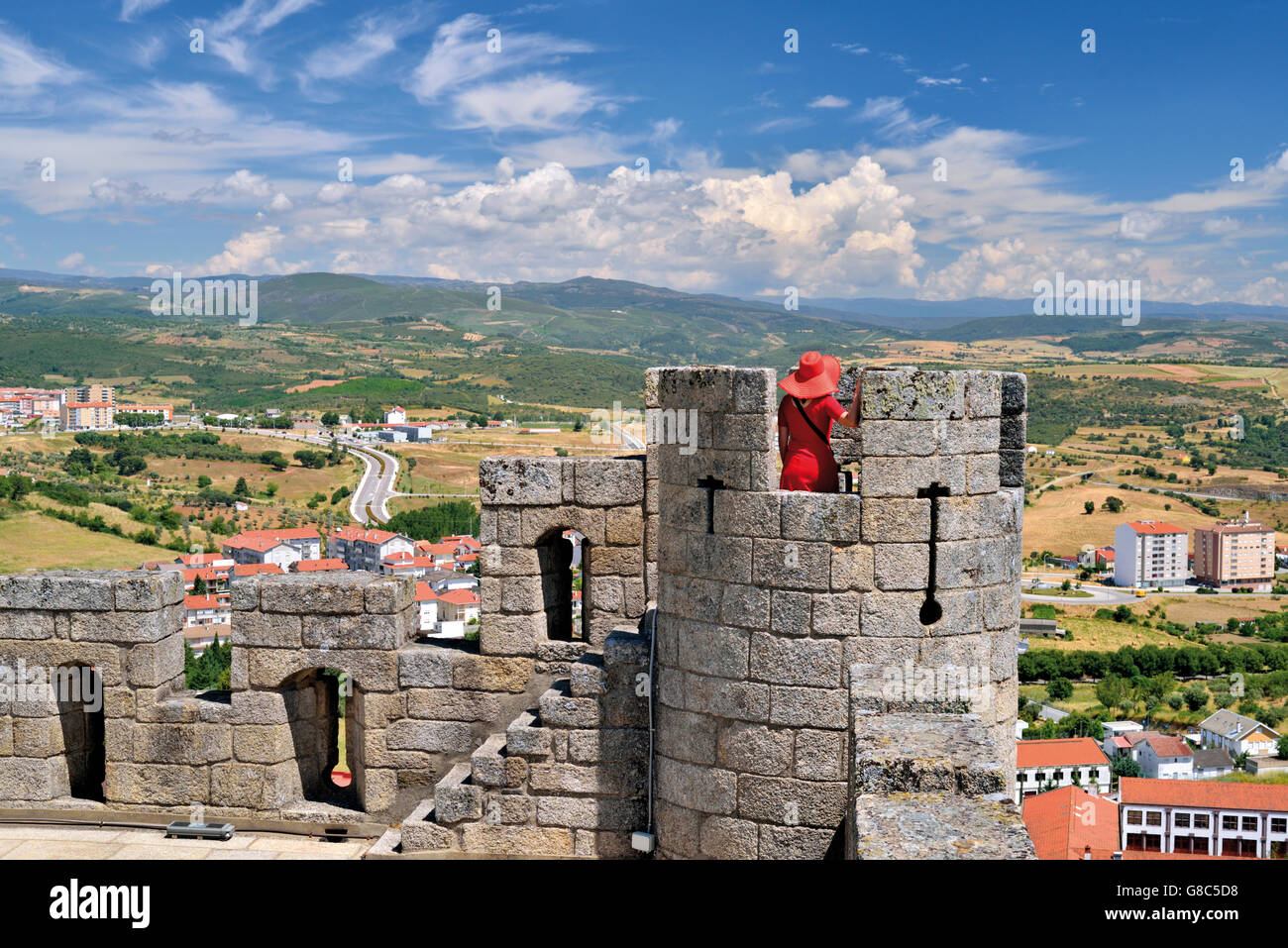 Portugal, Tras-os-Montes: Women with red hat and red dress on a view tower of the medieval castle of Braganca Stock Photo