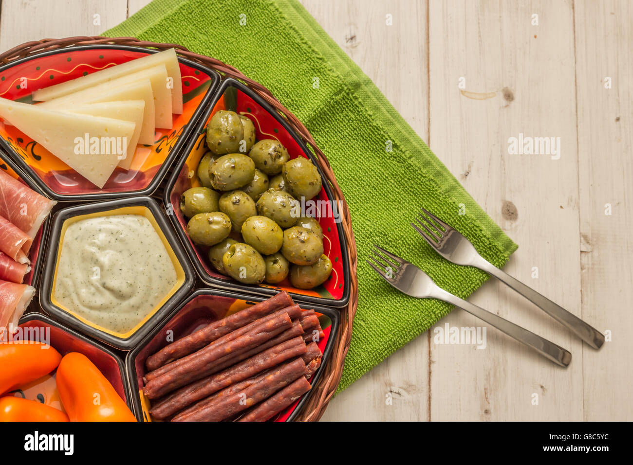 Basket with Spanish tapas on a rustic white wooden table Stock Photo ...