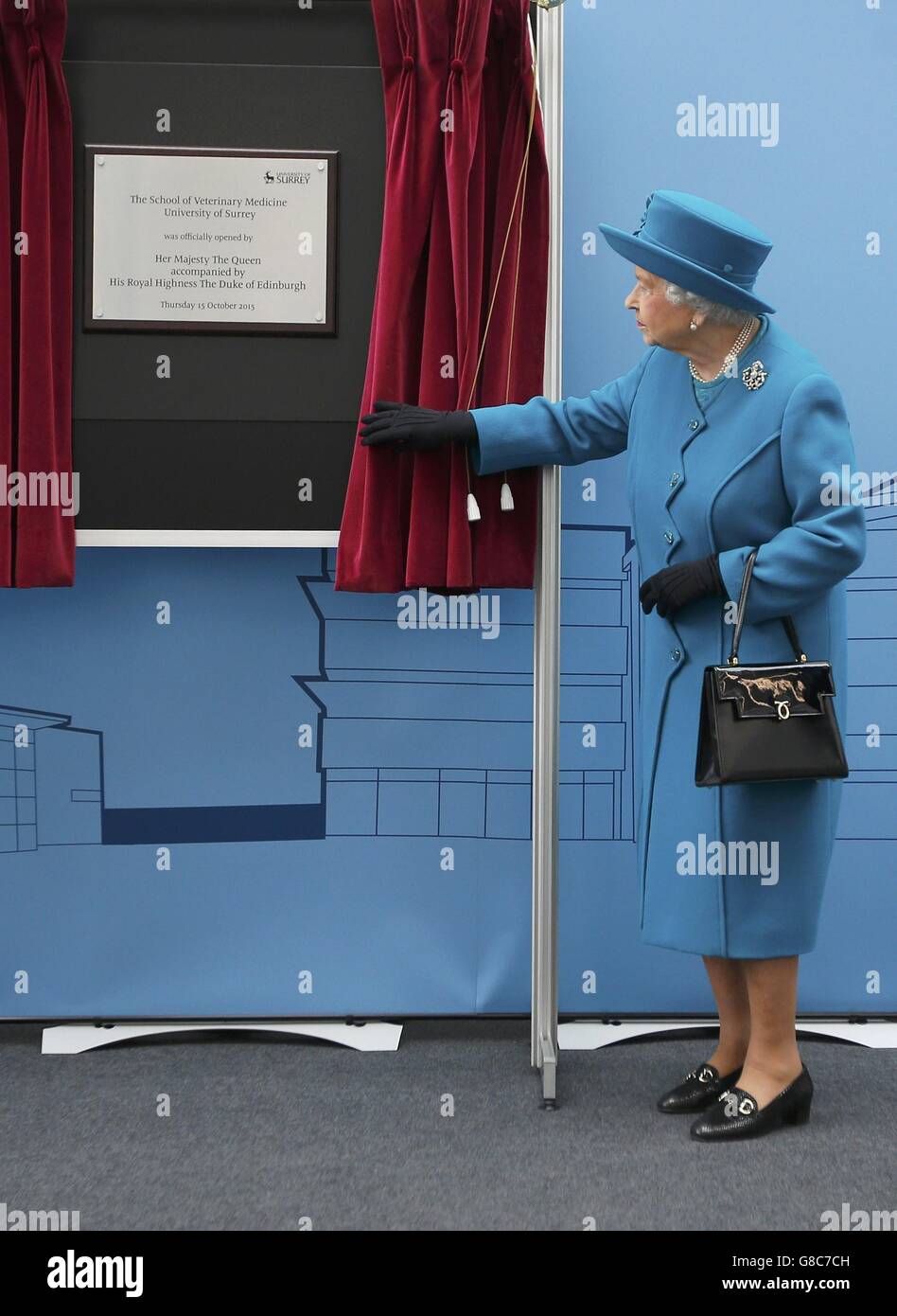 Queen Elizabeth II unveils a plaque at the University of Surrey in