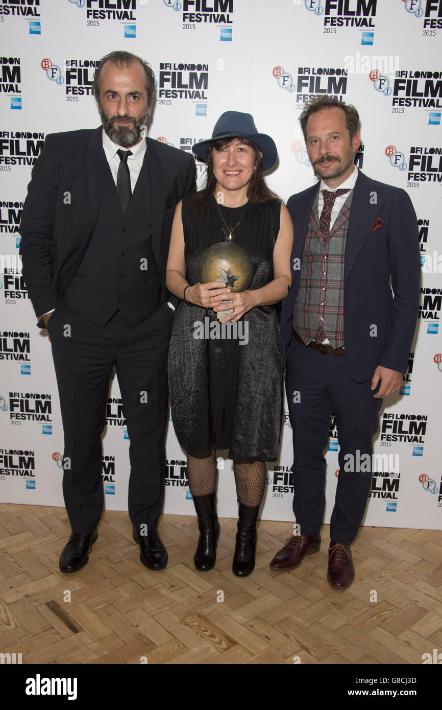 Greek filmmaker Athina Rachel Tsangari (centre), whose movie Chevalier won the Best Film Award, poses with Panos Koronis (left) and Torgos Pyrpassopoulos at the BFI London Film Festival awards at Banqueting House in London. Stock Photo