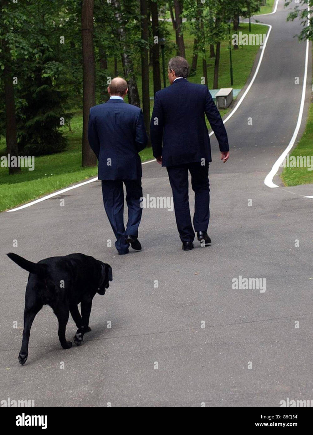 Britain's Prime Minister Tony Blair (right) walks with Russian President Vladimir Putin and his dog Konie at his private dacha outside Moscow. Stock Photo