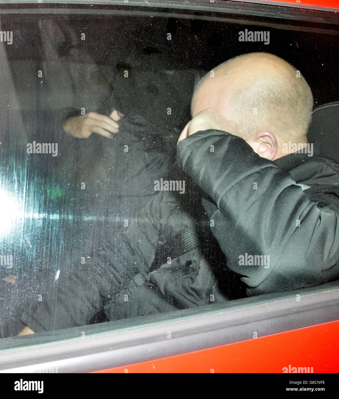 Pc Christopher Guest (nearside with head exposed) and Pc Cavan O'Connell (covered in a black coat) of West Midlands Police being driven away from a West Midlands Police misconduct hearing in Birmingham where told they will keep their jobs after leaving a foul-mouthed voicemail on the phone of an alleged domestic abuse victim, Alex Faragher. Stock Photo