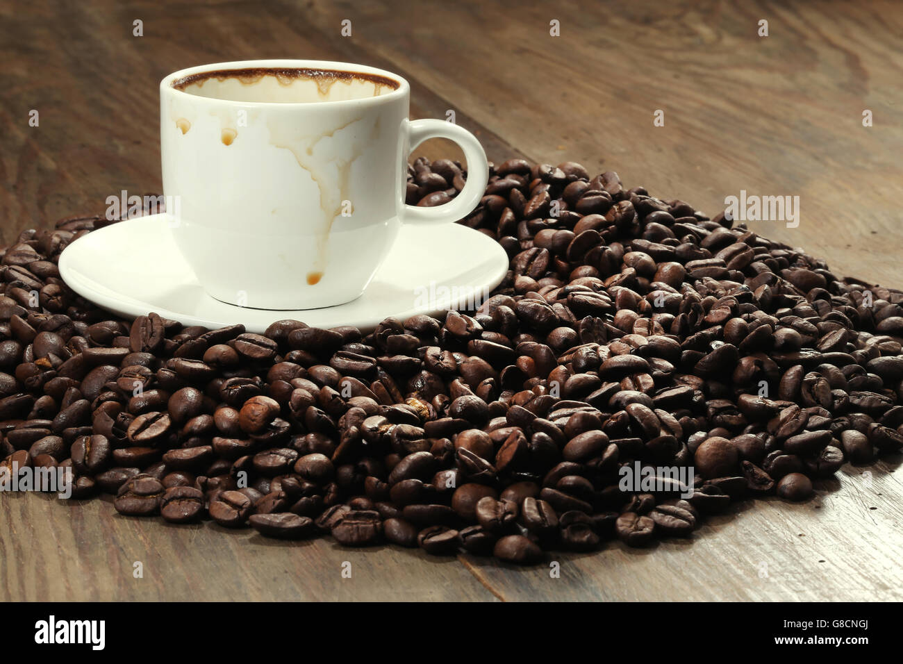 Coffee cup and coffee beans on a wooden table Stock Photo - Alamy