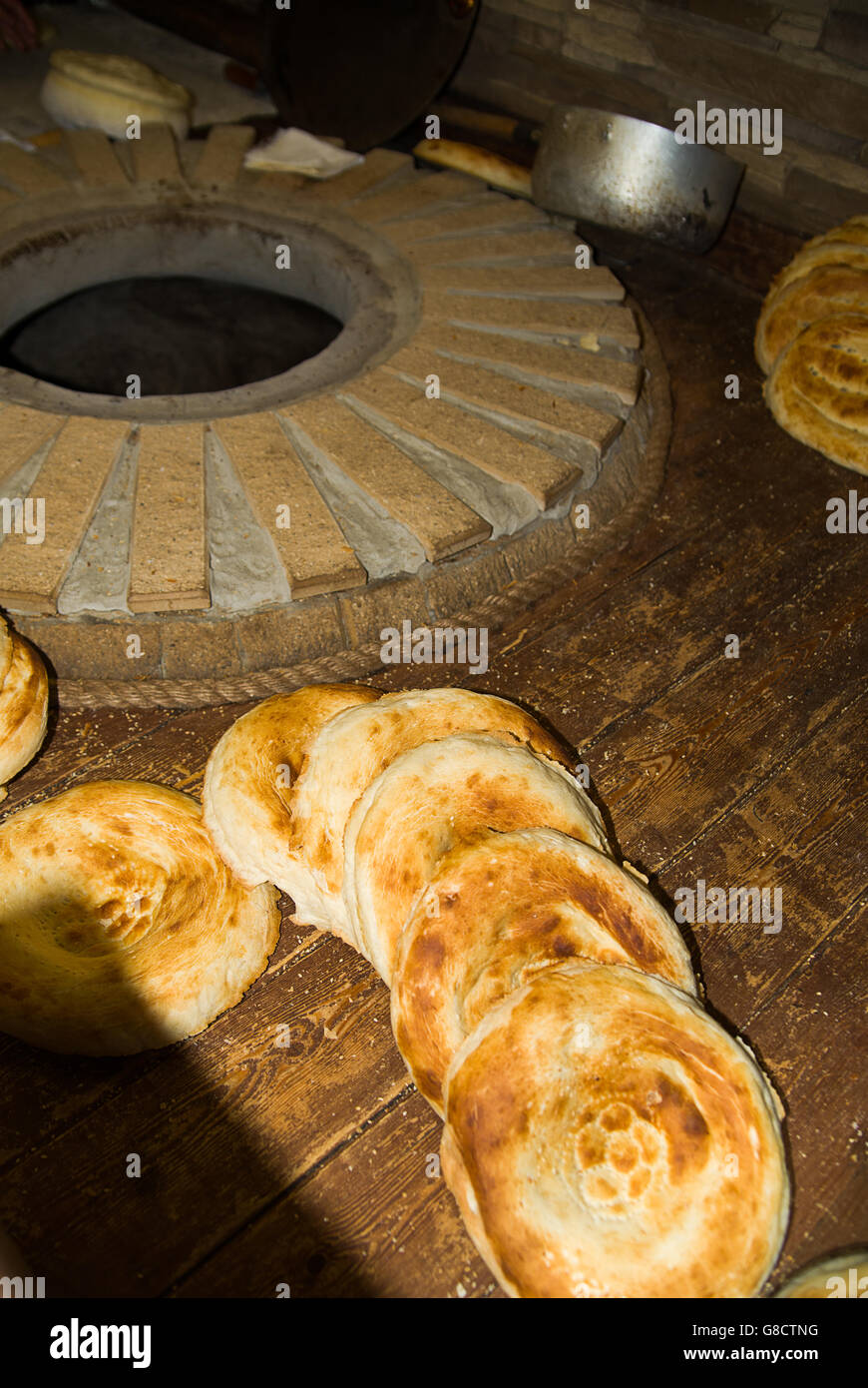 A few fresh-baked loaves of bread are next to the stove. Stock Photo