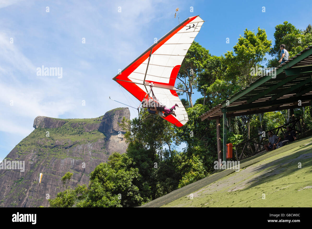 RIO DE JANEIRO - MARCH 22, 2016: A hang gliding instructor takes off with a passenger from Pedra Bonita, in the Tijuca Forest. Stock Photo