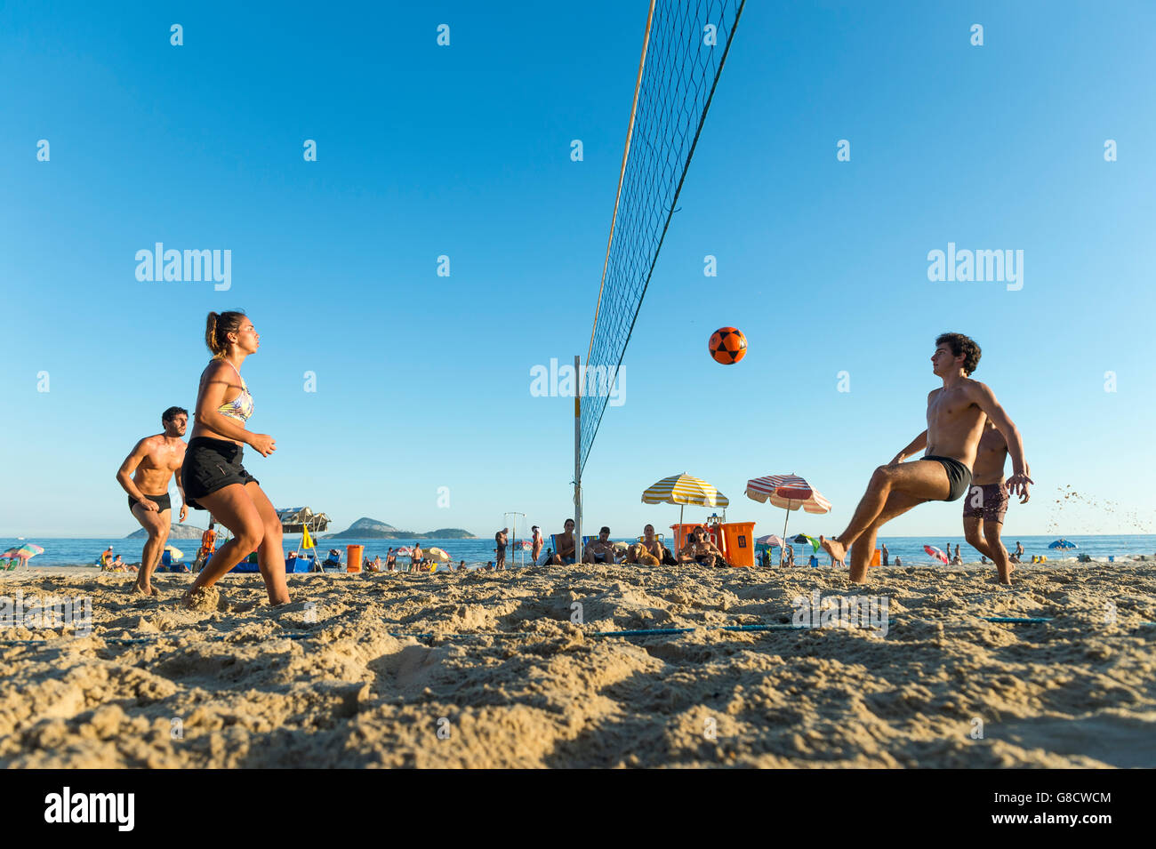 RIO DE JANEIRO - MARCH 17, 2016: Young carioca Brazilian men and women play a game of futevolei (footvolley) on Ipanema Beach. Stock Photo