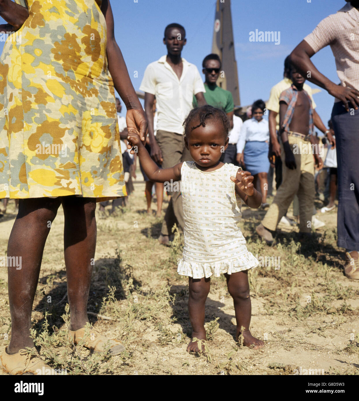 Rosalind Richardson, a 15 month old Anguillan toddler, watches British activity at the airstrip. British troops, as well as British Policeman, were sent to island following political unrest. The Island was bidding for independence from Great Britain. Stock Photo