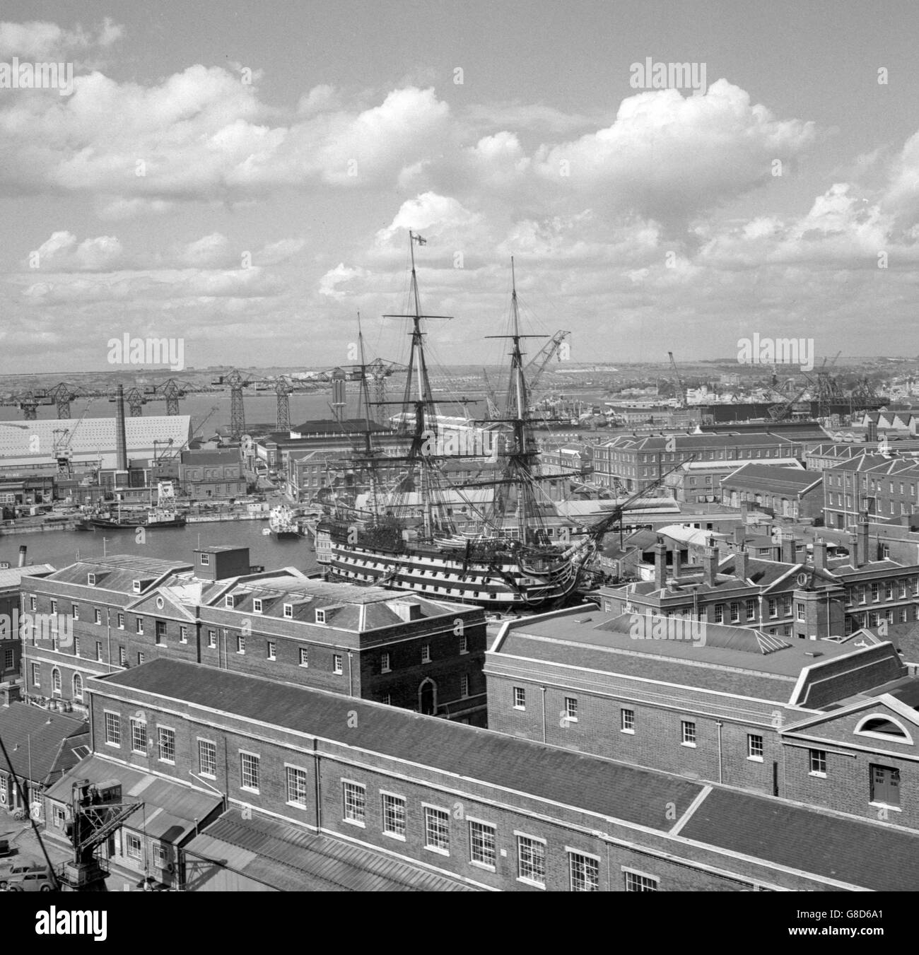 The wooden walls of 200 years ago stand out as a shrine of the nation's naval tradition amid the sprawl of a modern naval base in this picture of HMS Victory in Portsmouth. Stock Photo