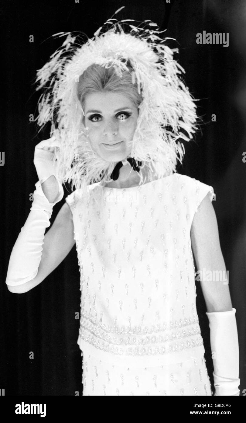 Simone Mirman, who designed this hat, shows off her creation at a Norman Hartnell dress show in London. The hat is made of white ostrich feathers and called 'Feather Brain'. Stock Photo