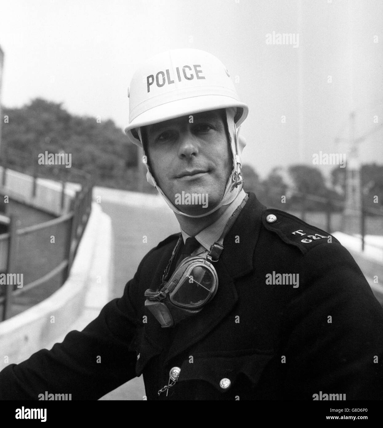 The new type crash helmet for police motorcyclists is worn by PC Gordon Hill, in Hampton, Middlesex. The helmet is white with the word 'Police' in blue. Stock Photo